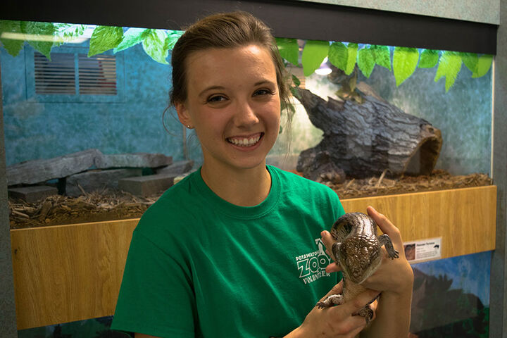 A volunteer holds a lizard at the Potawatomi Zoo.